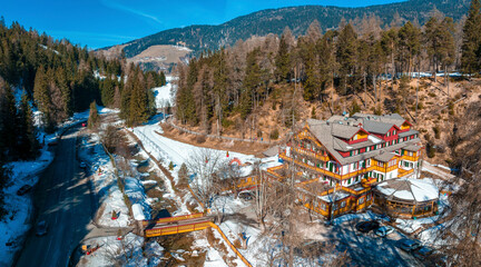 High angle view of parkhotel sole paradiso against forest. Panoramic view of beautiful resort on snow covered landscape in village. Holiday homes by road during winter.