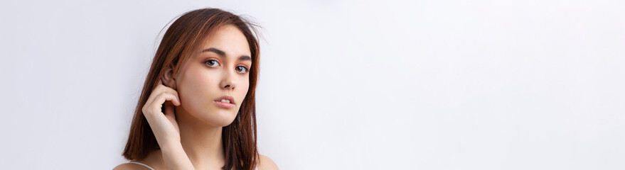 Obraz premium Beautiful smiling woman with clean skin, natural make-up and white teeth on a gray background