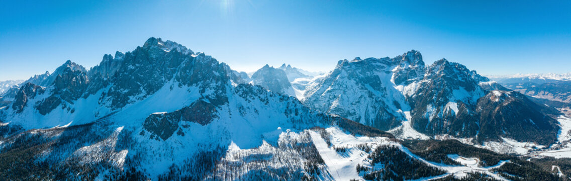 Panoramic view of snow covered mountain range against sky. Idyllic view of shadow falling on majestic alpine peaks. Beautiful nature during winter.