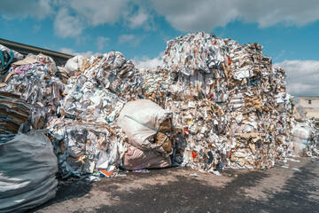 Heaps of waste paper, cardboard, newspapers and other paper waste folded for recycling. Reuse paper...