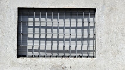 window with grille and shutter on white rustic facade - obrazy, fototapety, plakaty
