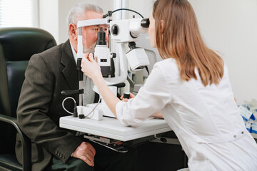 ophthalmologist examination of elderly man with slit lamp. medical equipment