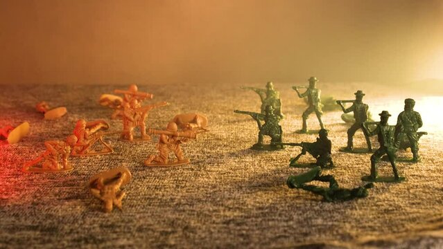 Plastic toy soldiers on the battlefield are falling in smoke. The concept of war and death on the battlefield