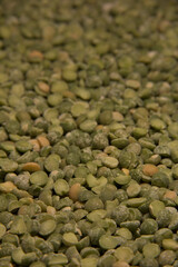 Background of green pea groats. Close up. Vertical.