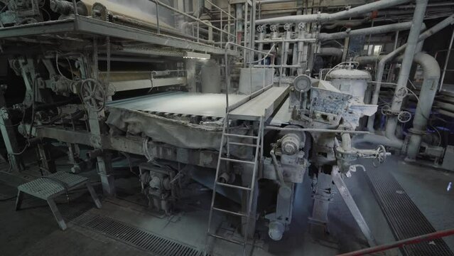 Paper production machine in wastepaper recycling factory. Paper and pulp mill.