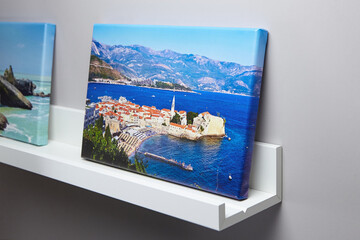 Canvas photo print with gallery wrapping and white shelf hanging on grey wall