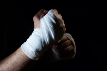 Hands of a boxer with white bandages prepared to fight in a sport battle