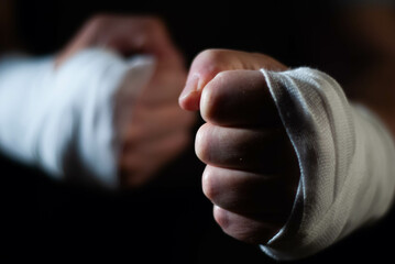 Hands of a boxer with white bandages prepared to fight in a sport battle