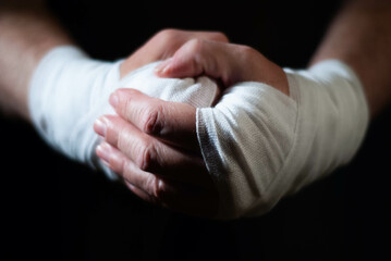 Hands of a boxer with white bandages prepared to fight in a sport battle