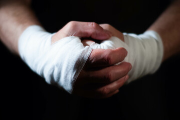 Hands of a boxer with white bandages prepared to fight in a sport battle