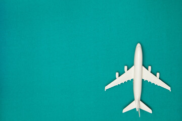 Airplane model. White plane on green background. Travel vacation concept. Summer background. Flat lay.