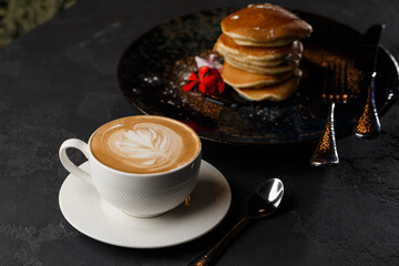 American pancakes with berries and maple syrup on black plate isolated with coffee. cafe menu