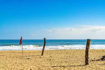 Playa Cocles, beautiful tropical Caribbean beach, Puerto Viejo, Costa Rica east coast and a wooden sticks and red flag