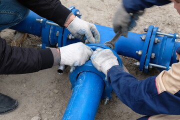 Workers installing water supply pipeline system, close up