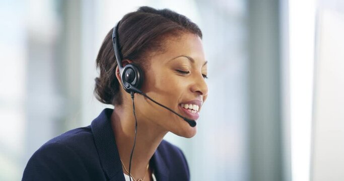 Im here to help. 4k video footage of an attractive young female callcenter agent working on a desktop in her office.