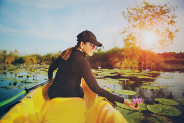 Fototapeta na wymiar woman sailing sea kayak in lotus flower lagoon