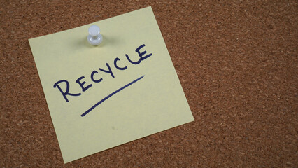 Note pinned on a cork board with a reminder to recycle.