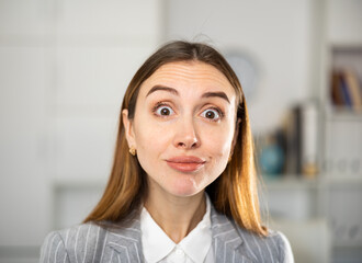 Closeup portrait of successful happy young business woman in office and looking at camera