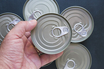 Mature man hand holding a can with canned food top view.