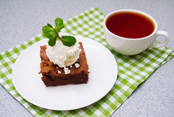 brownie portion with a ball of vanilla ice-cream on top. American traditional pastry. Cocoa powder and chocolate are main ingredients.