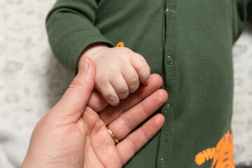 mother holds the baby by the hand
