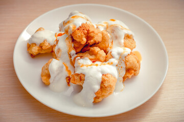 Fried cauliflower sauced with yoghurt and tomato paste in a white plate