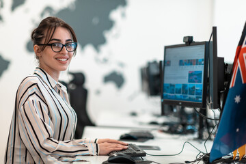 Casual business woman working on desktop computer in modern open plan startup office interior. Selective focus 