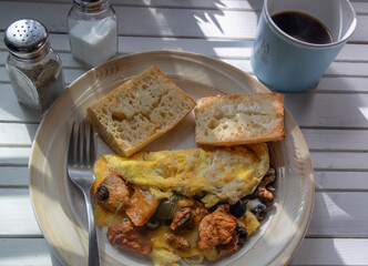 Chicken Omelette on a white natural wood table top.