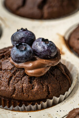 fresh baked muffins with chocolate cream and blueberries in ceramic pan