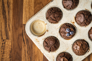 fresh baked muffins with chocolate cream and blueberries in ceramic pan copy space top view