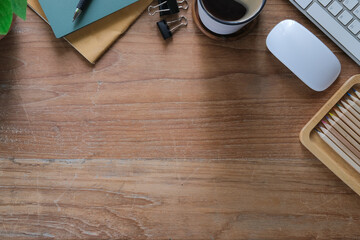 Above view simple workplace with books, coffee cup and pencils on wooden table.