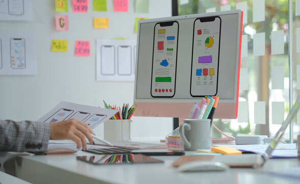 Web designer or developer planning application development draft sketch drawing template layout framework wireframe at design studio.