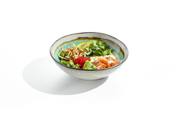 Healthy food - poke bowl with salmon, rice, cucumber, avocado, edamame beans, soybean sprouts and ponzu sauce. Hawaiian meal poke bowl with salmon isolated on white background.