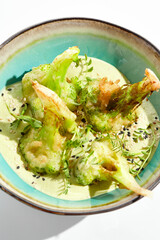 Fried tempura broccoli with peanut sauce in bowl. Vegeterian hot dish - florets cabbages roasted  in klar on white background. Veggie menu for asian restaurant. Hot vegan appetizers plant based.