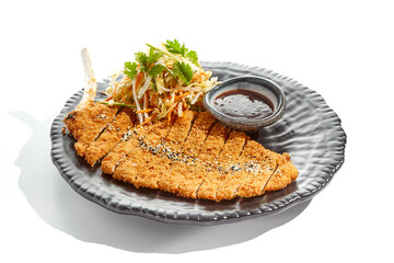 Authentic German schnitzel with cabbage salat and sauce on black plate. Breaded meat - popular restaurant dish Viennese schnitzel. Thin slice of meat breaded with vegetables salad on white background. - obrazy, fototapety, plakaty