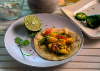 Top view of tacos with mango, avocado, jalapeno, tomato and red onion