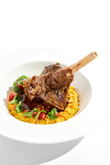 Slow roast leg of lamb with pumpkin stew and grilled tomatoes. Lamb leg with vegetables isolated on white background. Main course on fine dining. Gourmet dish from meat on bone. Meat menu.