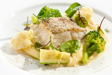 Roasted cod with mashed potatoes and broccoli. White fish fillet with skin with vegetables isolated on white background. Healthy food in restaurant menu. Fish and cabbages in minimalism style.