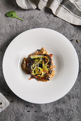 Braised beef cheeks with pearl barley and celery in creamy mushroom sauce. Veal cheek with mushroom risotto on gray stone background. Main course concept. Food menu for restaurant.