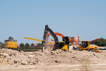 Hydraulic crusher backhoe machinery working on site demolition