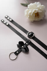 Black leather fetish collar with a bow. Fetish stuff for bdsm role playing games. Close-up