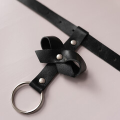 Black leather fetish collar with a bow. Fetish stuff for bdsm role playing games. Close-up