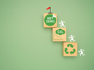 Net-zero greenhouse gas emissions target. Wooden cubes with CO2 green icons over a green background.