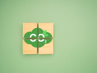 Wooden cubes with CO2 green icons over a green background