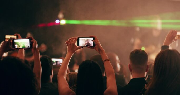 One night, lots of awesome memories. 4k video footage of a crowd of people photographing a live musical performance with their smartphones.