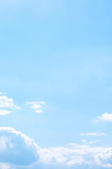 Soft fluffy cumulus clouds above the light blue sky in sunny day. Purity of natural white cloudscape scene with copy space. Vertical background. Freedom and calm of nature concept. Outdoor fresh air.