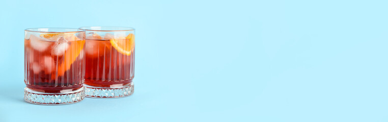 Glasses of tasty Negroni cocktail on color background with space for text