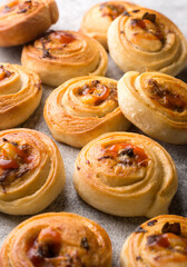 freshly baked spiral shaped curry buns on a textured table top, homemade food, taken in shallow depth of field