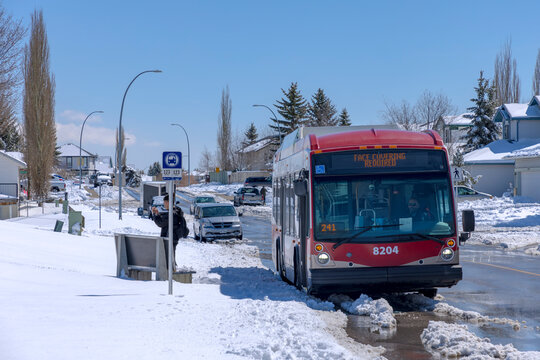 Calgary, Alberta, Canada. Apr 20, 2022. A Calgary Transit Nova Bus LFS 40102 model on a bus stop during a snowing winter day.