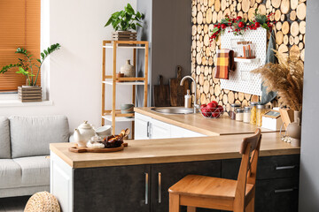 Interior of stylish kitchen with wooden counters, silver sink and shelving unit